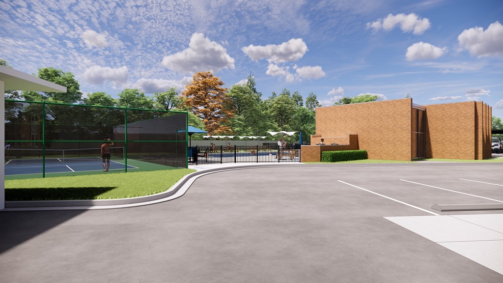 A man is playing tennis on a court with a green fence and a building in the background.