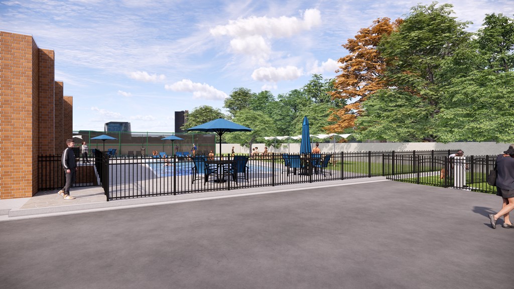 A person is walking in a courtyard with a pool and umbrellas.