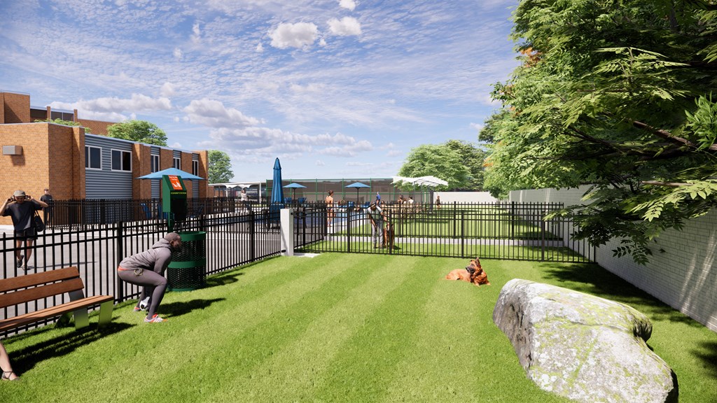 A park with a green lawn and people sitting on benches.