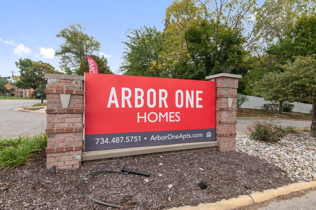 a sign that reads arbor one homes in front of a street