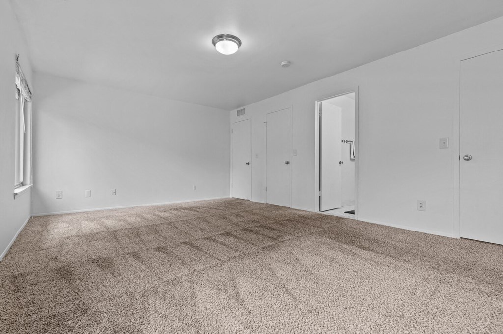 an empty living room with carpet and white walls at Edge At Farmington Hills - Farmington Hills, MI, Michigan