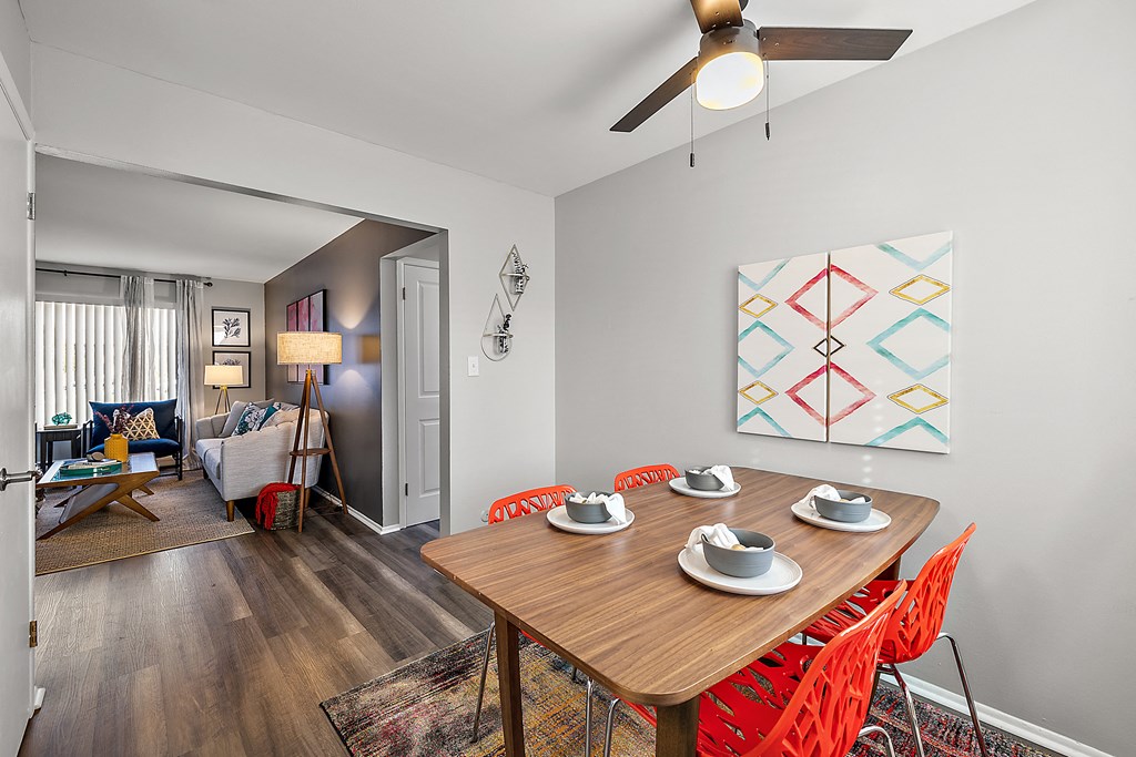 a dining room with a wooden table and chairs and a ceiling fan