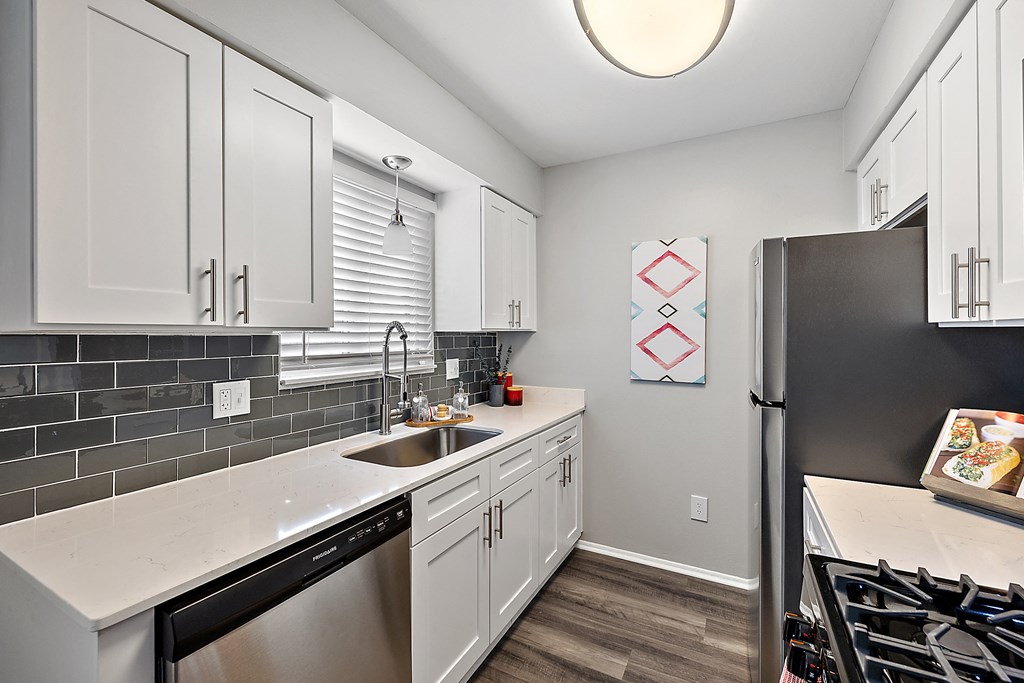 a kitchen with white cabinets and a stainless steel refrigerator