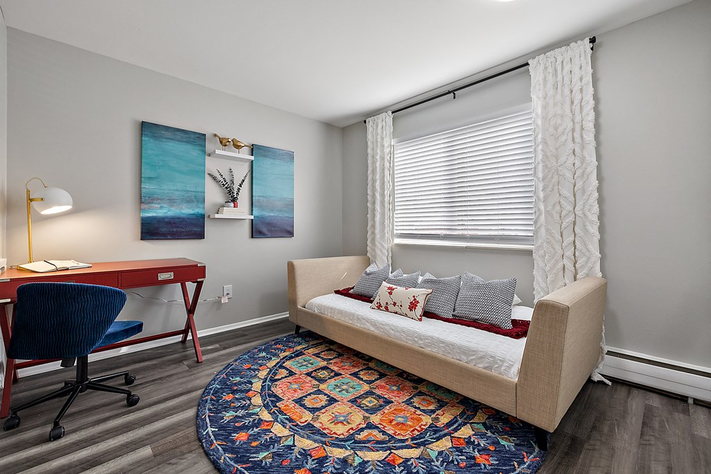 a living room with a couch and a desk with a chair