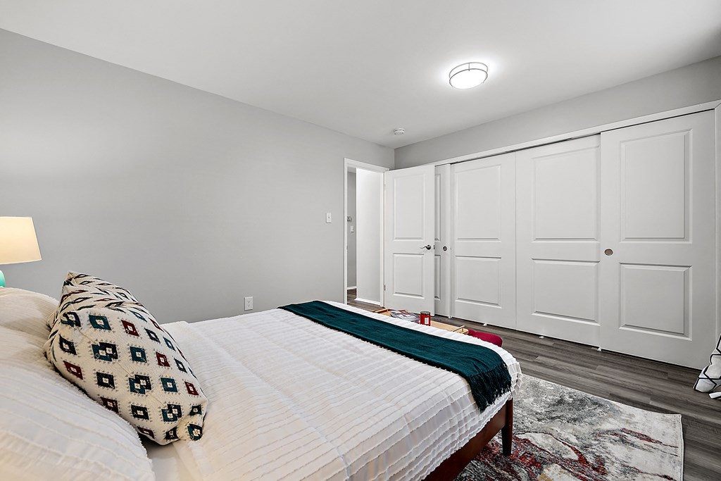 a bedroom with a large bed and white closet doors