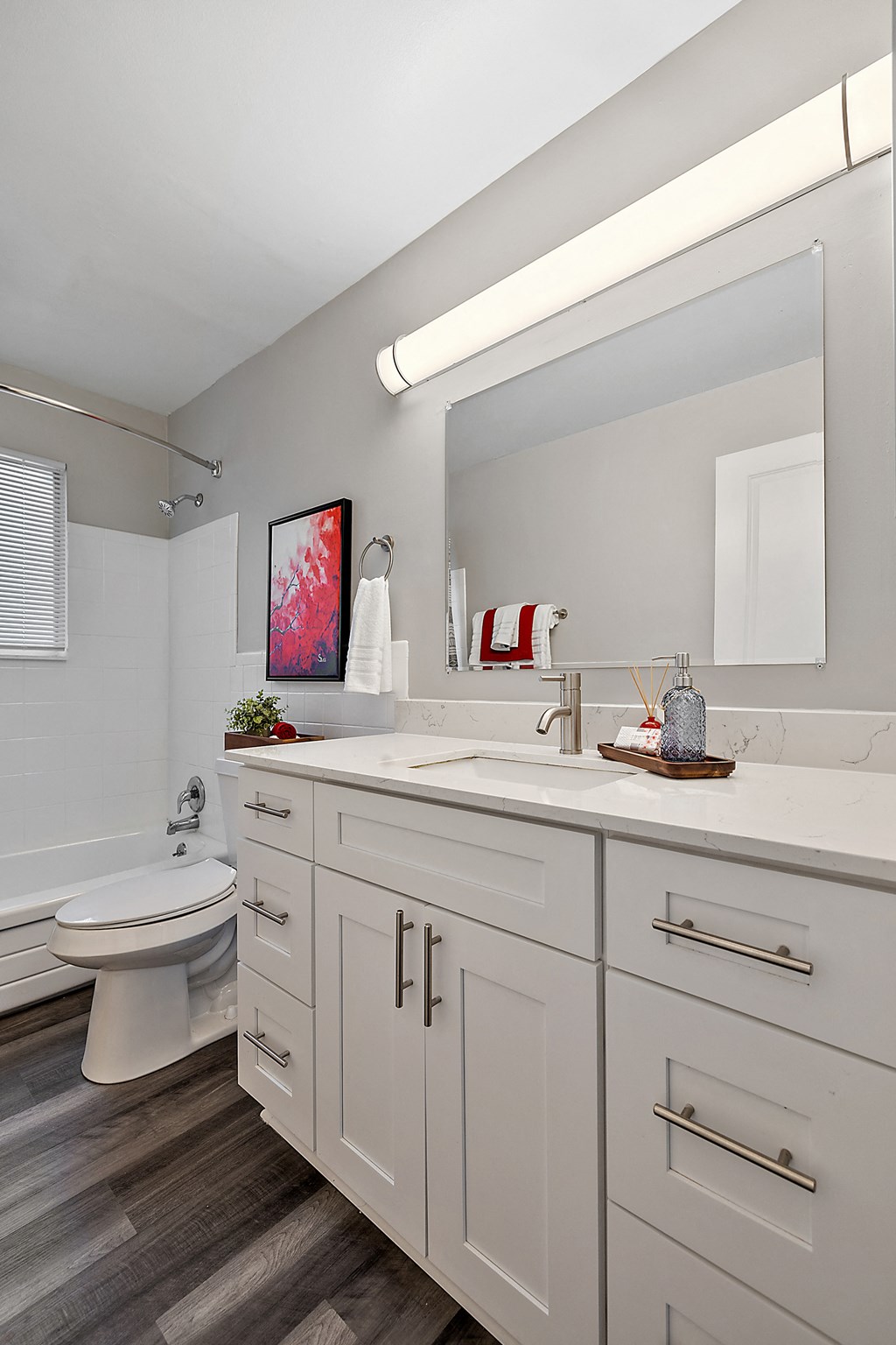 a bathroom with white cabinets and a toilet and a sink