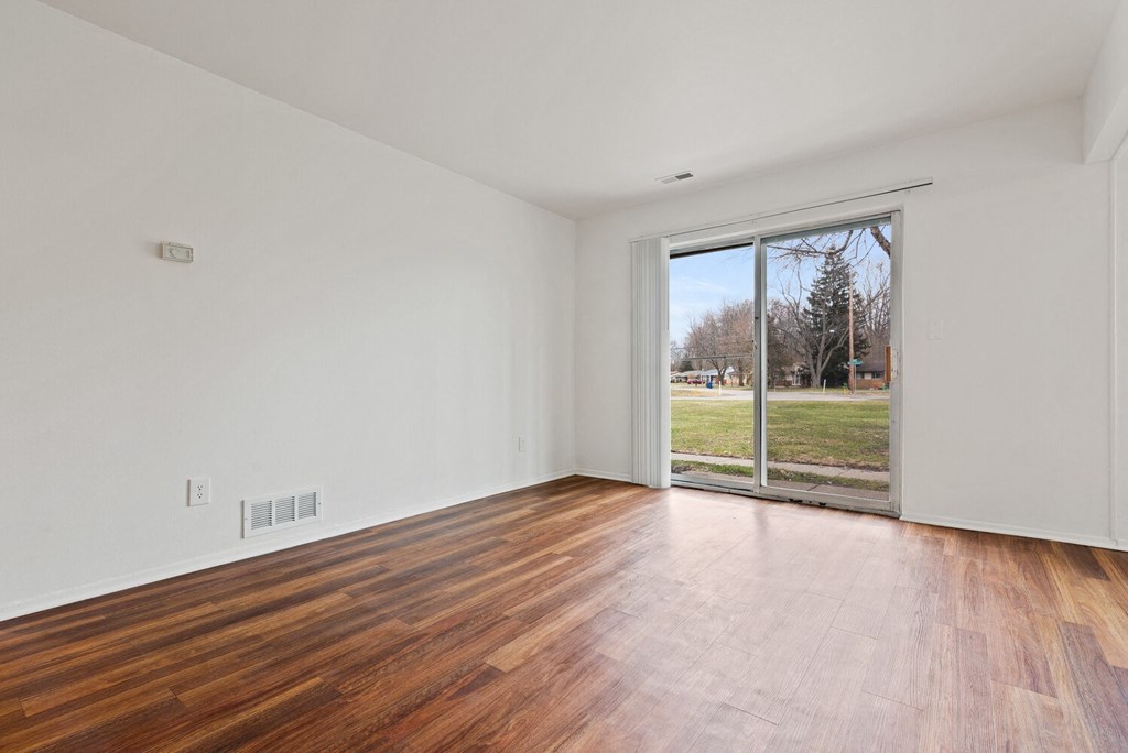 a living room with wood floors and a sliding glass door