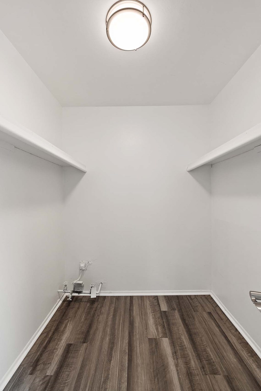 a living room with white walls and wood floors