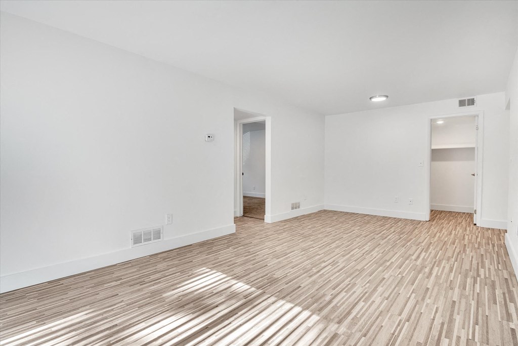 a living room with a hard wood floor and white walls