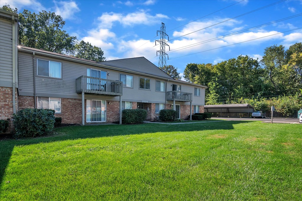 a large green lawn in front of an apartment building