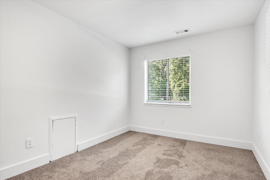 an empty room with carpet and a window