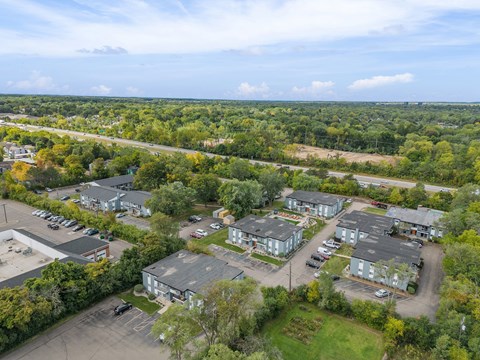 A bird's eye view of a parking lot with several cars and buildings.