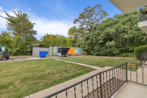 A metal fence surrounds a concrete patio.