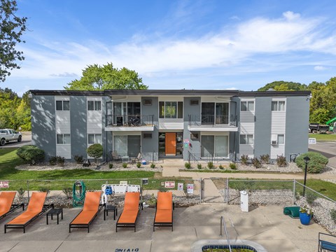 A sunny day at the outdoor pool area of a modern apartment complex.