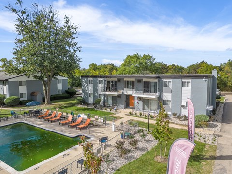 A sunny day at a poolside with chairs and a banner.