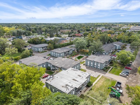 A large industrial building surrounded by trees and other buildings.
