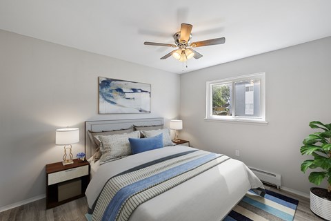 A bedroom with a bed, nightstand, and a ceiling fan.