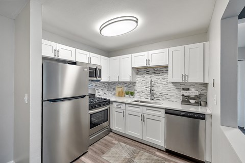 A modern kitchen with stainless steel appliances and white cabinets.