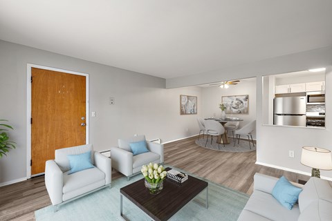 A living room with a brown door, a white couch, a coffee table, and a plant.