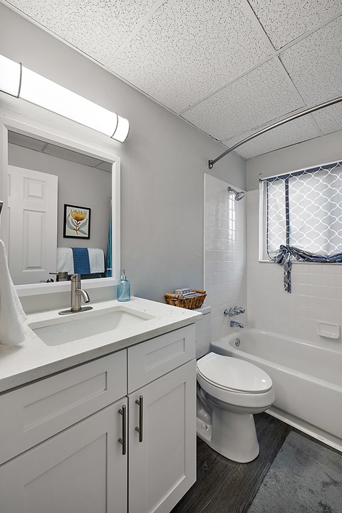 A white bathroom with a toilet, sink, and bathtub.