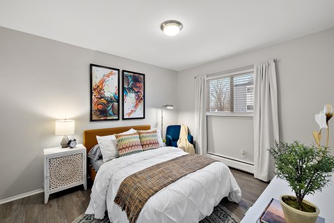 A bedroom with a large bed and two framed pictures on the wall.