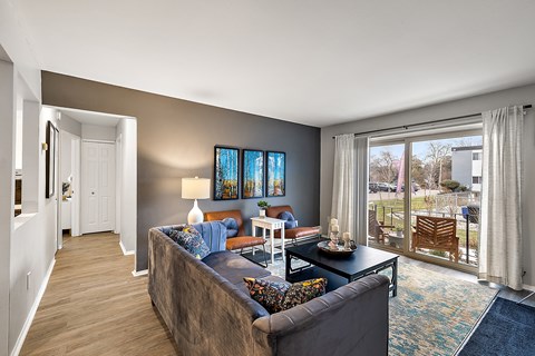 A living room with a couch, a chair, a coffee table, and a painting on the wall.