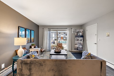 A living room with a couch, a coffee table, and a lamp.