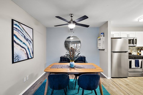A dining room with a wooden table and blue chairs.