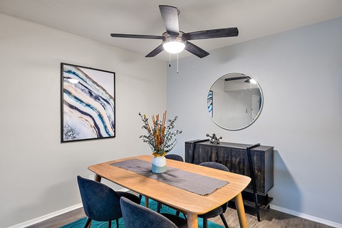 A dining room with a wooden table and chairs.
