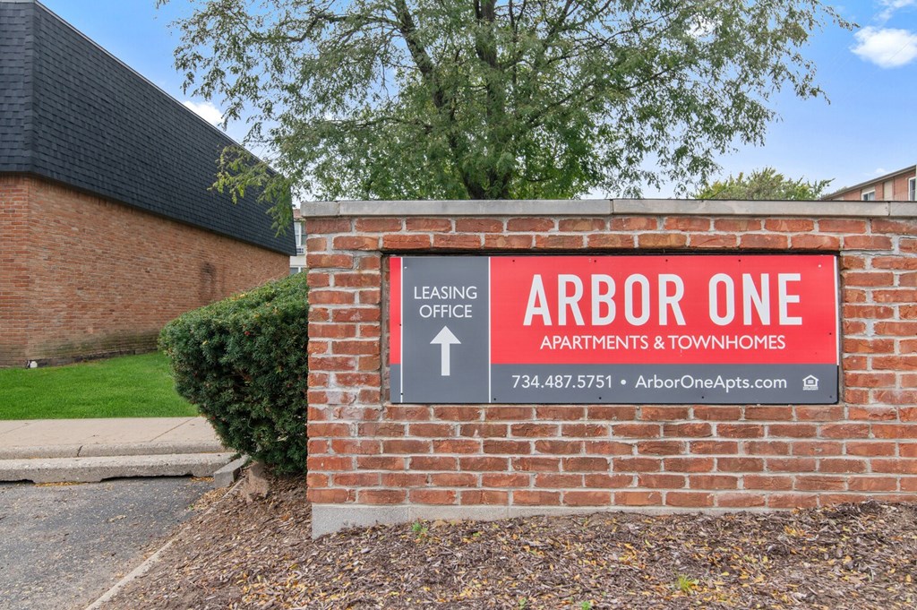 a brick building with a sign that reads arbor one apartments  townhomes