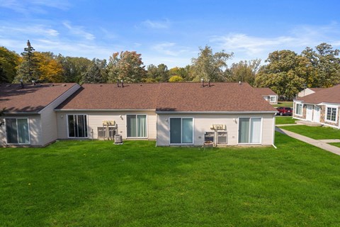a white house with a brown roof on a green lawn