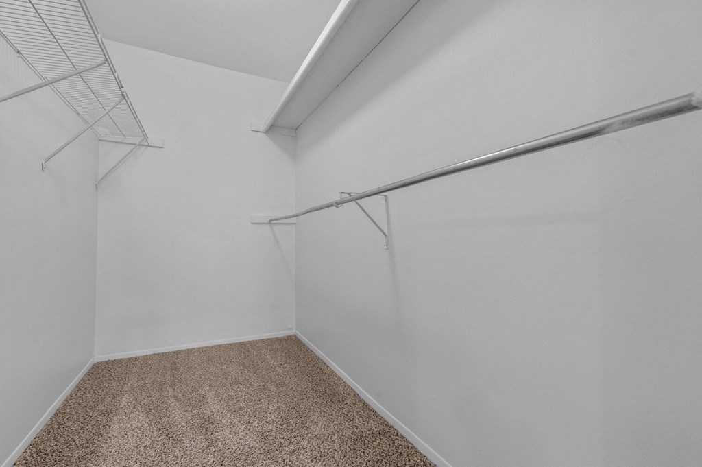 an empty room with white walls and a closet with a metal rail on the wall at Edge At Farmington Hills - Farmington Hills, MI, Michigan