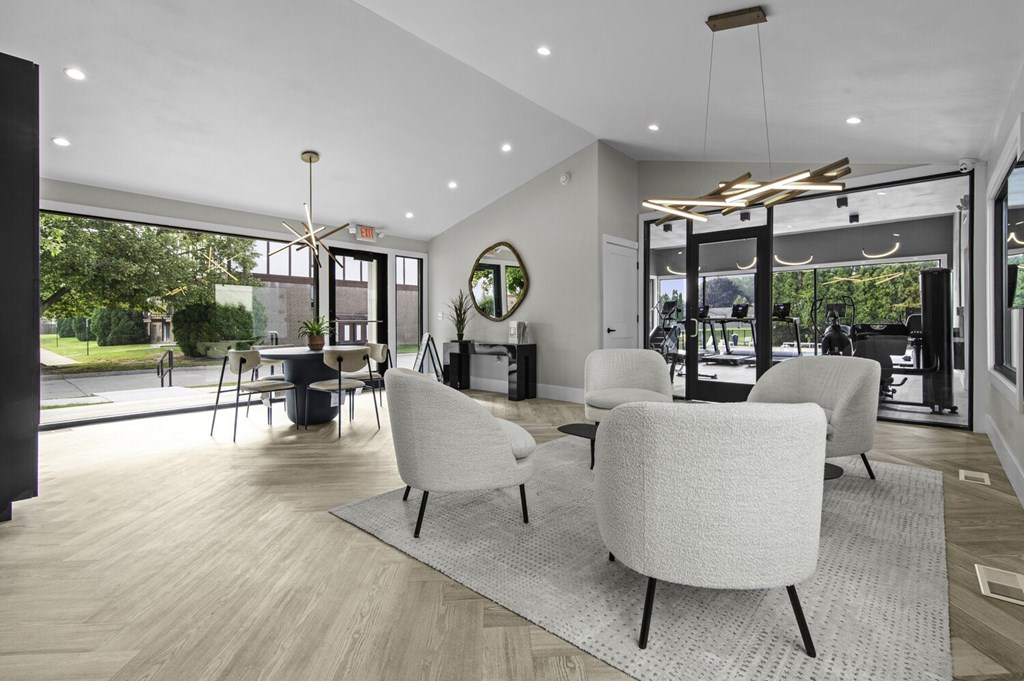 A modern living room with white furniture and a large window.