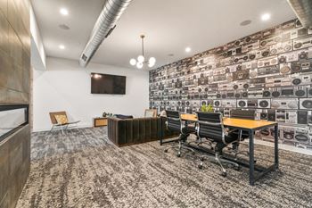 a conference room with a brown couch and a wooden table with black chairs