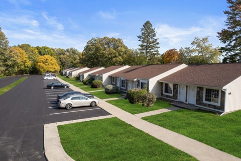 a row of houses with cars parked in a parking lot