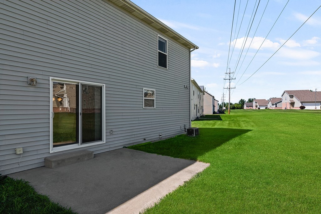 a side view of a house with a yard and a sidewalk