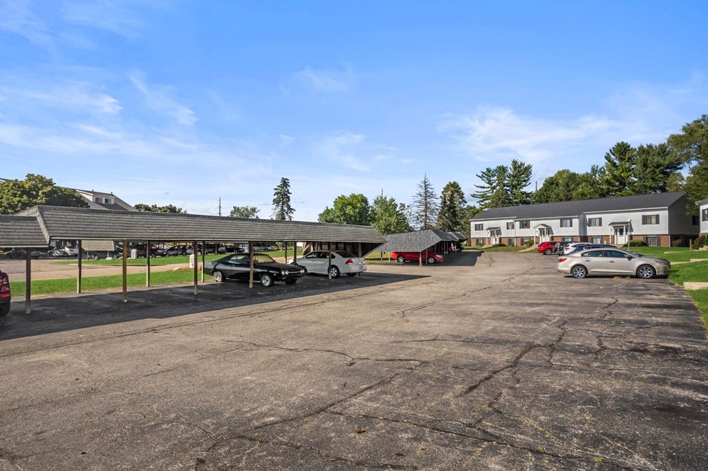 a parking lot with cars in front of a house