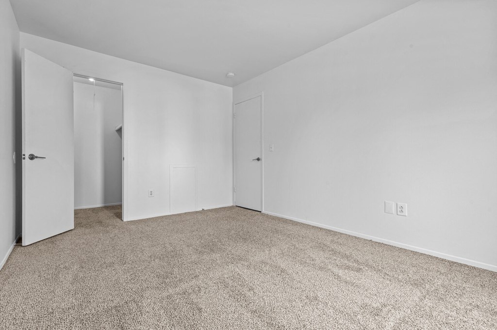 a bedroom with white walls and carpet