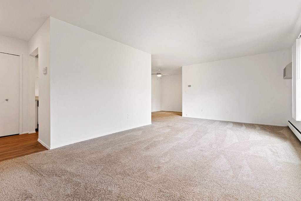 an empty living room with white walls and carpet