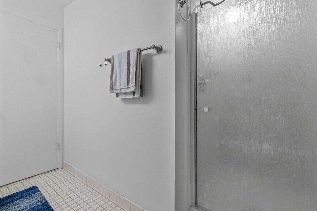 a bathroom with a shower and a towel hanging on a towel rack at Edge At Farmington Hills - Farmington Hills, MI, Farmington Hills