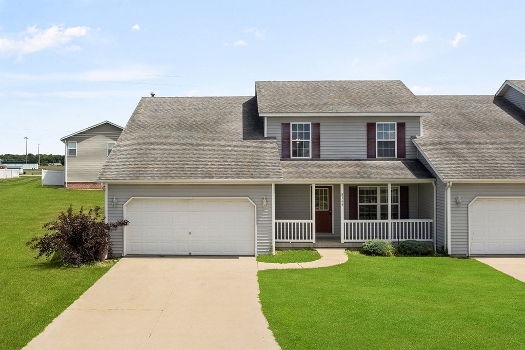 a house with a lawn and a sidewalk in front of it