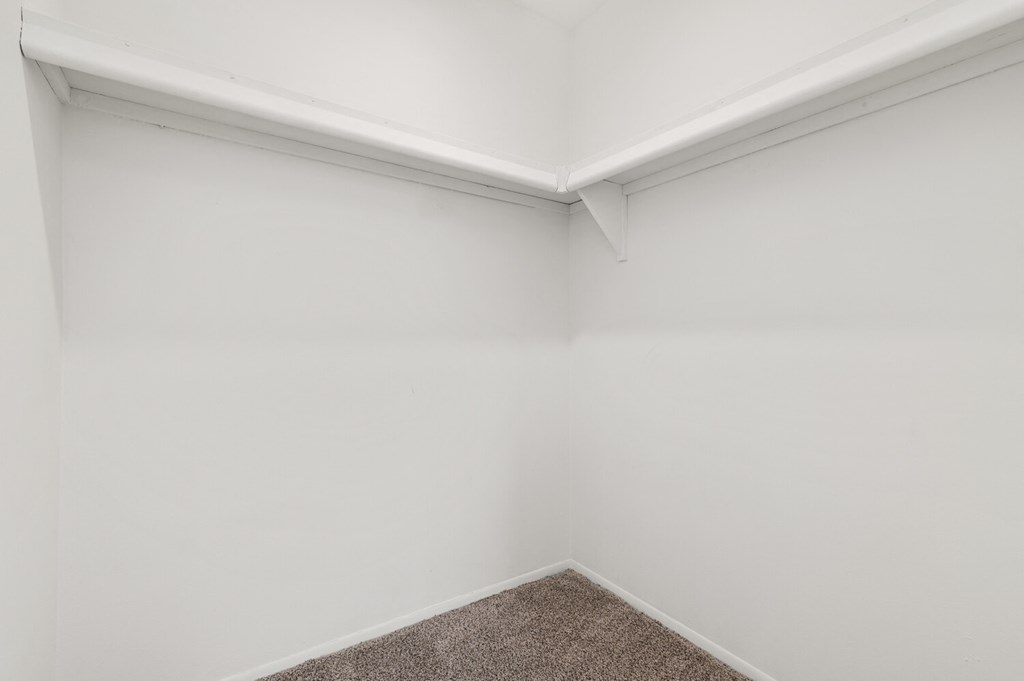 an empty room with white walls and a carpet