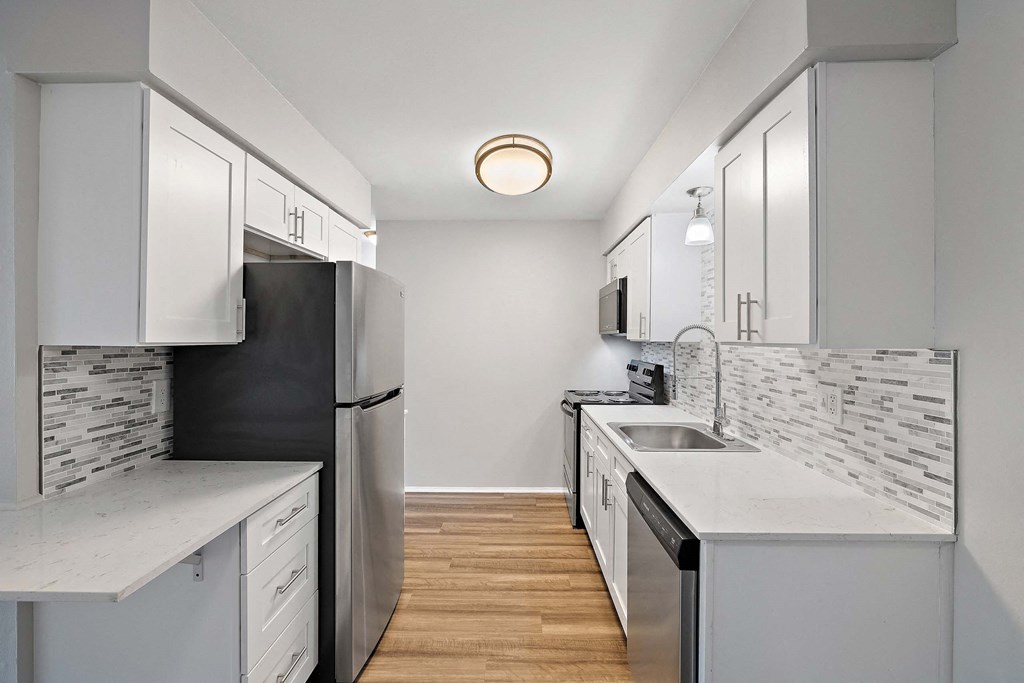 a renovated kitchen with white cabinets and stainless steel appliances