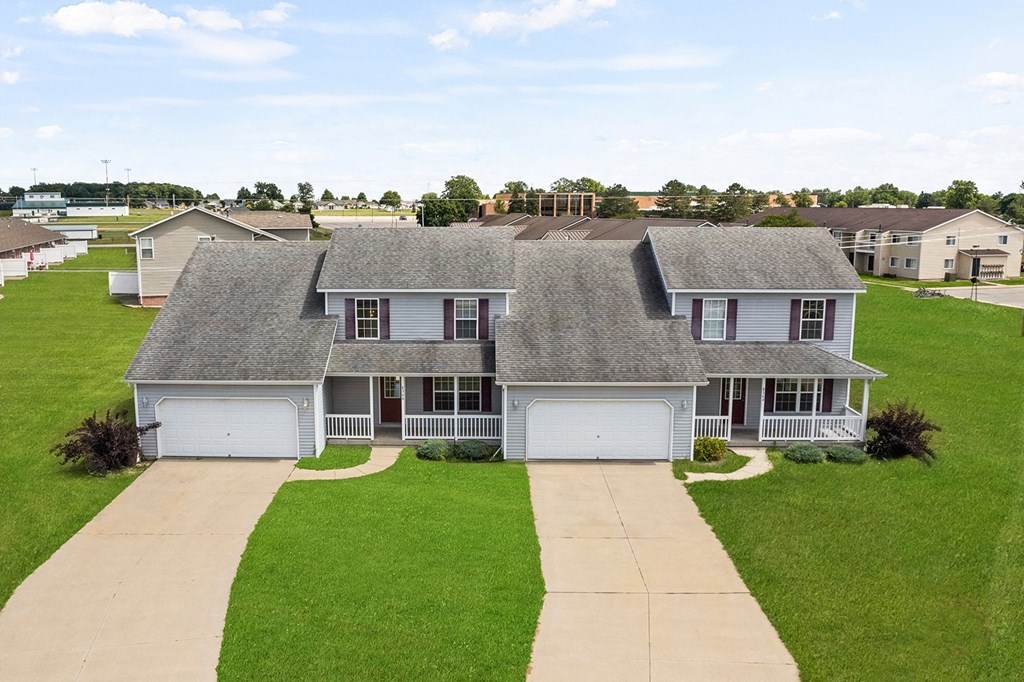 a white house with a gray roof on a green lawn