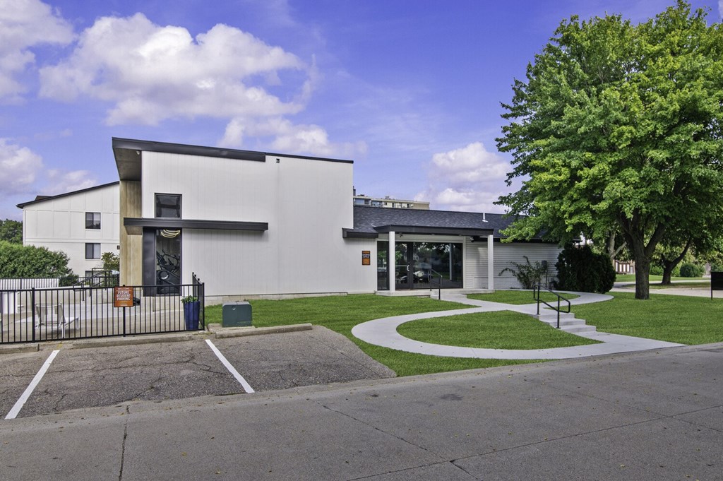 A white building with a black gate in front.