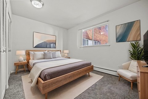 A bedroom with a large bed and a painting on the wall.