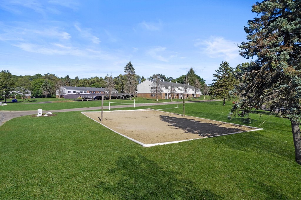 the park has a volleyball court in the middle of the grass
