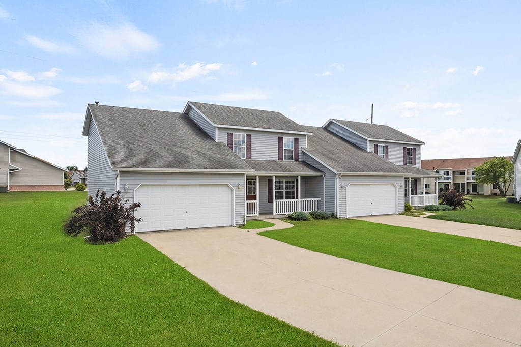 a white house with a driveway and a lawn