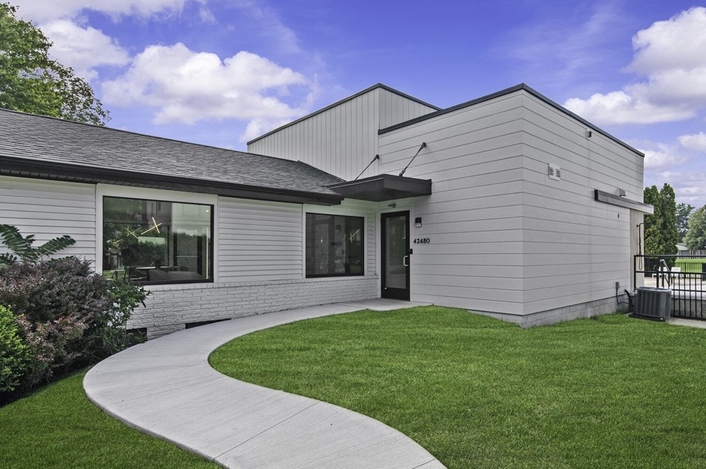 A modern building with a grey exterior and a black roof.