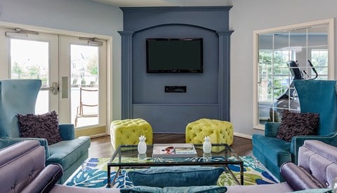 a living room with blue walls and yellow chairs and a television